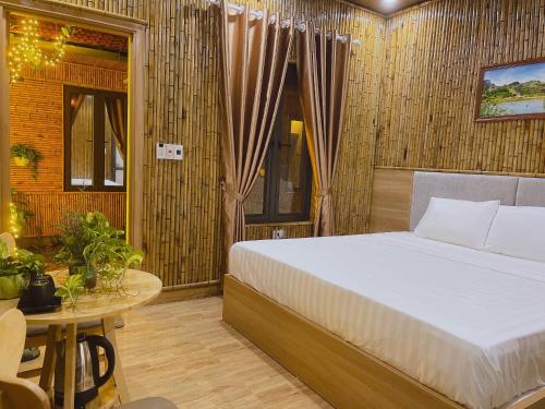 a bedroom with a large bed and a table at Tam Coc Viet Ha Homestay in Ninh Binh