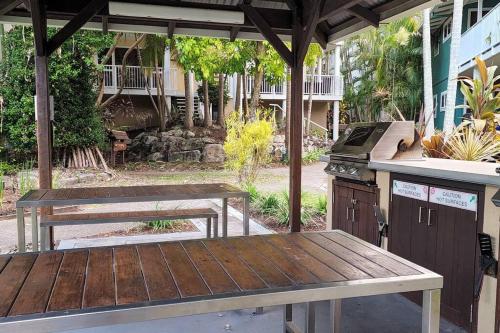 a patio with a picnic table and a grill at Luxury Top Floor Sunset Villa in Noosaville