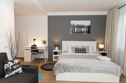 a bedroom with a large bed and a couch at Warsawrent Apartamenty Centralna in Warsaw