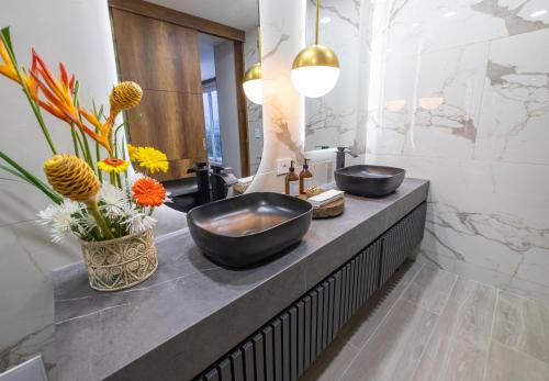a bathroom with two sinks on a counter with flowers at Hotel Casa Giraldo in Armenia