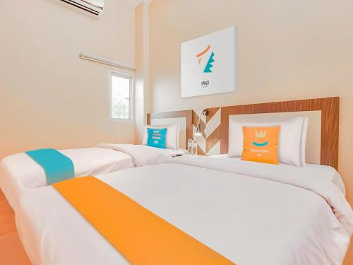 Ένα ή περισσότερα κρεβάτια σε δωμάτιο στο Sans Hotel City Inn Palangkaraya