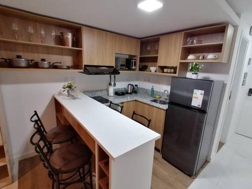 a kitchen with a black refrigerator and a counter at Hermoso Departamento completamente equipado in Colonia Mariano Roque Alonso