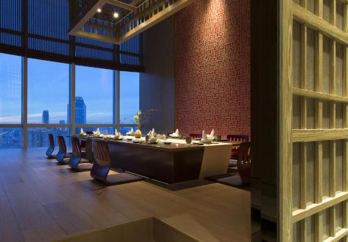 a dining room with a long table with chairs at Pullman Yantai Center in Yantai