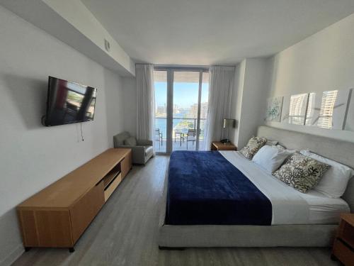 a bedroom with a large bed and a television at 1 BD 1 BA @Beachwalk Resort in Hallandale Beach