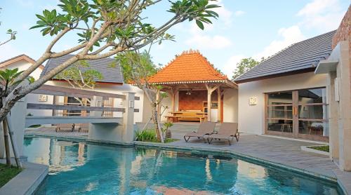 a villa with a swimming pool and a house at Vivara Bali Private Pool Villas & Spa Retreat in Jimbaran