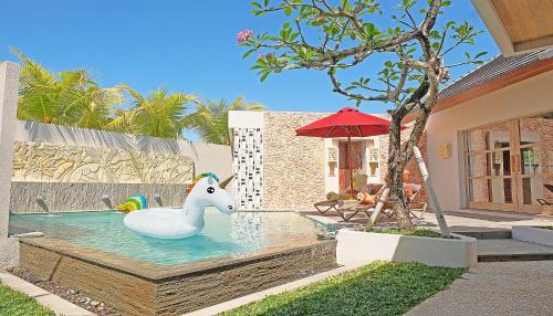 a pool with a plastic unicorn in the water at Vivara Bali Private Pool Villas & Spa Retreat in Jimbaran