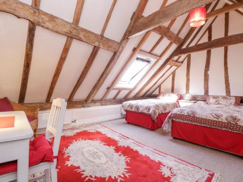 a bedroom with two beds in a attic at Brew Cottage in Chislet