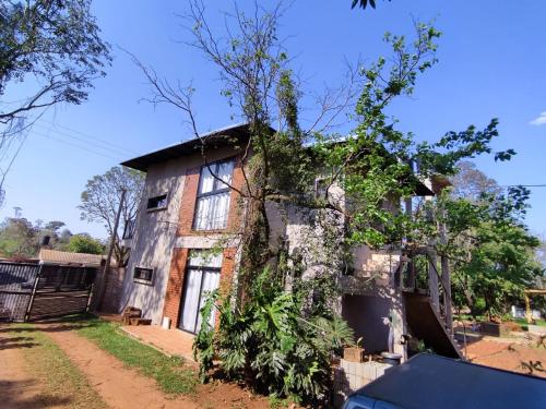 een oud huis met wijnstokken erop bij Naturalis Flats and Suites in Puerto Iguazú