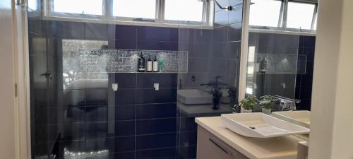 a bathroom with two sinks and a shower and a mirror at Impressive Central Apartment in Warrnambool