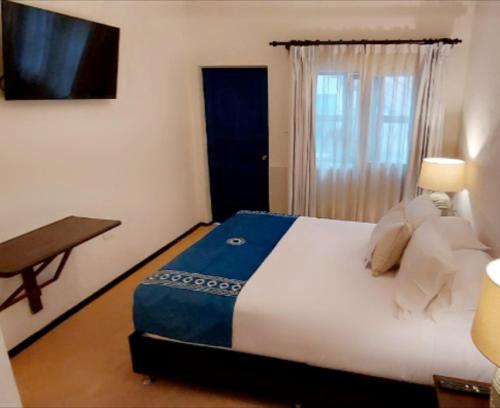 a bedroom with a bed and a desk and a television at Katari at Plaza de Armas Cusco in Cusco