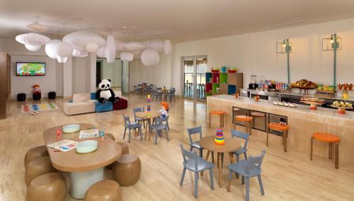 a living room with tables and chairs and a panda bear at Paradisus Grand Cana, All Suites - Punta Cana -All Inclusive in Punta Cana