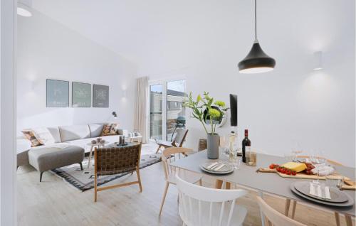 ein weißes Wohnzimmer mit einem Tisch und Stühlen in der Unterkunft 3 Bedroom Awesome Home In Lembruch-dmmer See in Lembruch