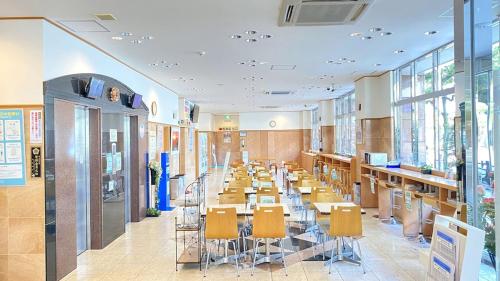 a cafeteria with tables and chairs and windows at Toyoko Inn Matsuyama Ichibancho in Matsuyama
