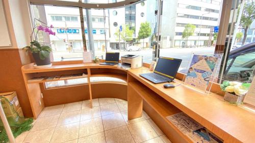 a desk with two laptops on it in a window at Toyoko Inn Matsuyama Ichibancho in Matsuyama