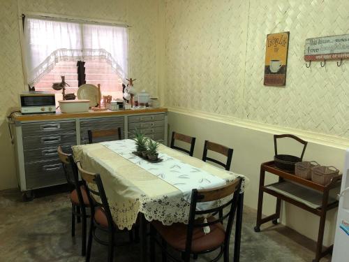 a kitchen with a table with chairs and a table and a counter at Hiraya Homestay Coron in Coron