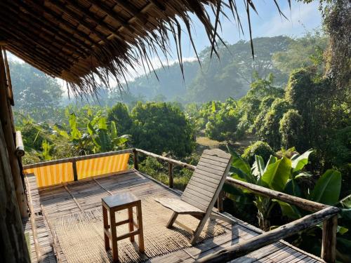 a deck with chairs and a view of the mountains at Chiang Dao Hostel in Chiang Dao