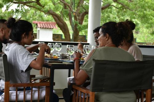a group of people sitting at a table eating food at Funky Leopard Safari Lodge Bordering Yala National Park in Kataragama