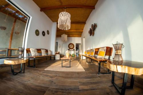 a living room with couches and tables and a chandelier at Hotel Boutique Beso de Sal in Colán