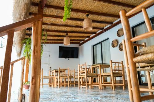 a room with a table and chairs and a tv at Hotel Boutique Beso de Sal in Colán
