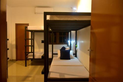a room with two bunk beds and a hallway at Funky Leopard Safari Lodge Bordering Yala National Park in Kataragama