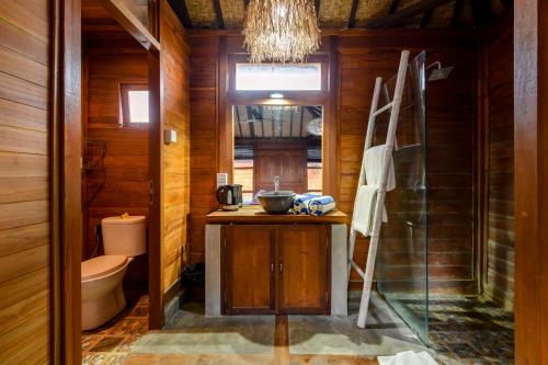 a bathroom with a sink and a toilet and a chandelier at Turtle Villas, Canggu by Manara in Canggu