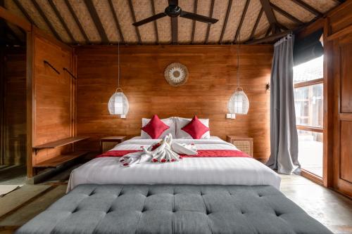 チャングーにあるTurtle Villas, Canggu Managed by Manaraのベッドルーム1室(大型ベッド1台、赤い枕付)