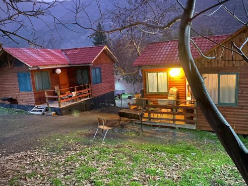 une cabane en rondins avec une table et des chaises en face de celle-ci dans l'établissement Cabañas Between Hills, à San Alfonso