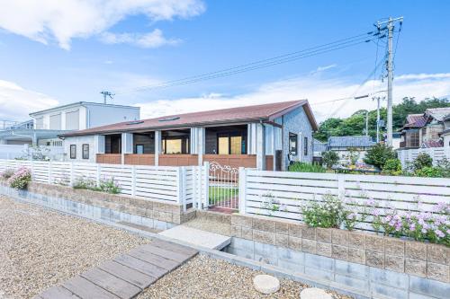 a house with a white fence in front of it at Sunset Villa Awaji in Awaji