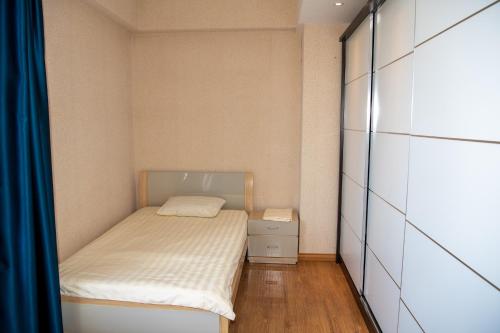ein kleines Schlafzimmer mit einem Bett und einem Schrank in der Unterkunft Lovely 2 BR unit with city view in Ulaanbaatar