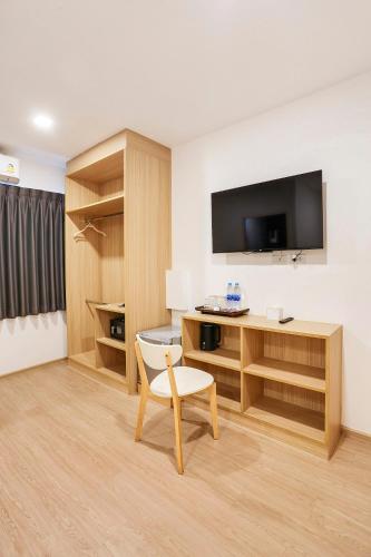 a room with a desk and a tv and a chair at TAKKA Hotel - Bangna in Bangna