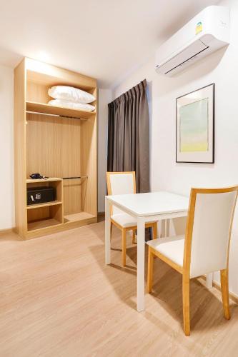 a dining room with a white table and chairs at TAKKA Hotel - Bangna in Bangna