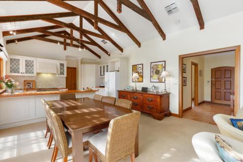 Una cocina y un comedor con mesa y sillas de madera. en Elcott House - Carrickalinga - C21 SouthCoast Holidays, en Carrickalinga