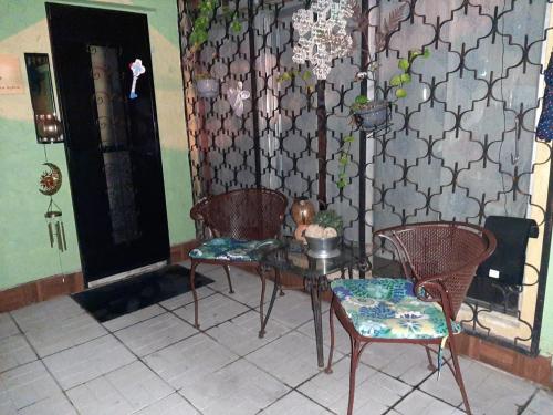 a room with two chairs and a table and a wall at Nirvana Hermosa habitación individual e independiente in Guatemala