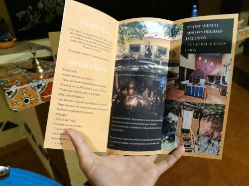 a person holding a book in their hand at Hostal Tribu Malinalco in Malinalco