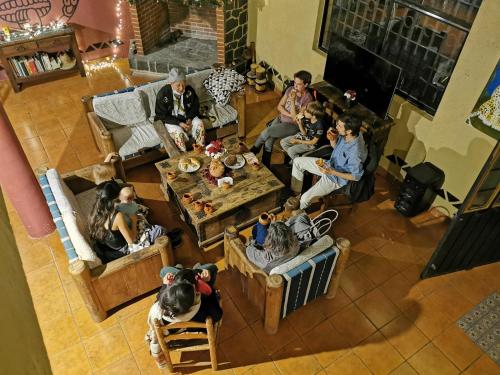 a group of people sitting in a living room at Hostal Tribu Malinalco in Malinalco