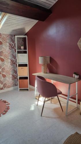 a living room with a table and a chair at Maison de charme au cœur des vignes du Beaujolais in Saint-Georges-de-Reneins