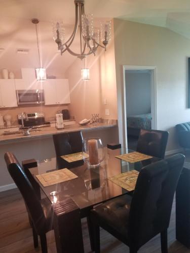 ein Esszimmer und eine Küche mit einem Glastisch und Stühlen in der Unterkunft Home Sweet Home in Fort Myers