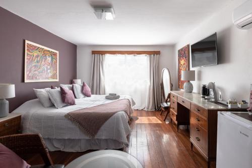a bedroom with a bed with pink pillows and a sink at VIOLETA HOTEL Boutique in Artigas