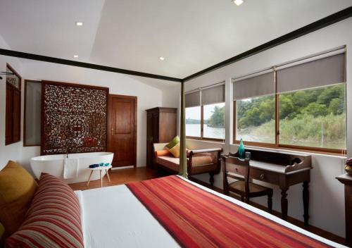 a bedroom with a bed and a desk and a tub at Marina by DAE in Piliyandala