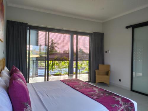 1 dormitorio con cama grande y ventana grande en Villa Bintang, en Lovina