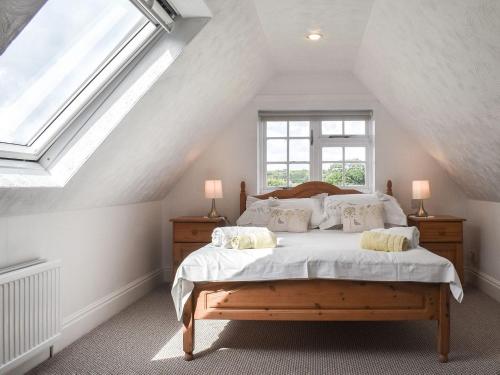 1 dormitorio con 1 cama con sábanas y almohadas blancas en The Coach House - Uk41070 en Wootton Bridge