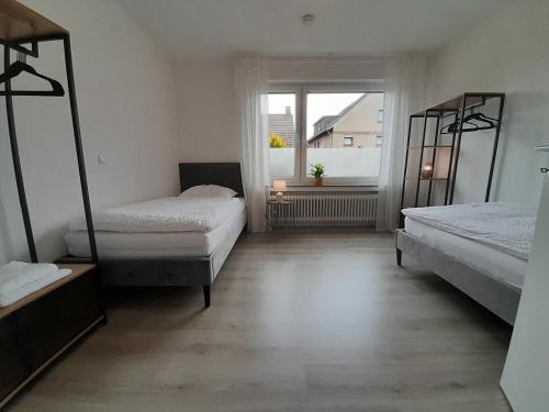 een kamer met 2 bedden en een raam bij 4-Zimmer-Ferienwohnung, modern, Küche, WLAN, Netflix in Castrop-Rauxel