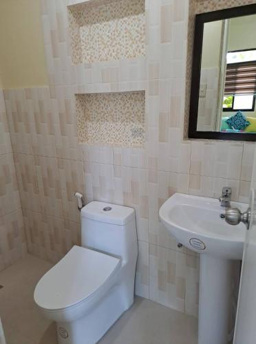 a bathroom with a white toilet and a sink at Happy's Homestay in Boracay