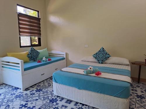 a bedroom with two beds and a chair in it at Happy's Homestay in Boracay