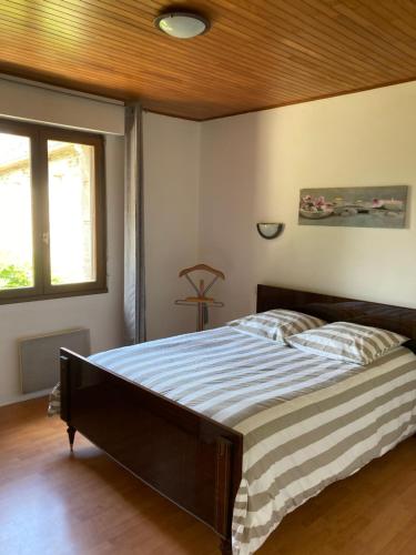 Maison de campagne de plein pied. في Plougonven: غرفة نوم بسرير كبير بسقف خشبي