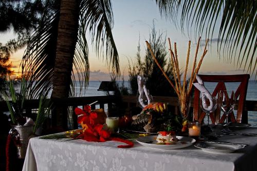 a table with plates of food on top of the ocean at Hibiscus Boutique Hotel in Pereybere