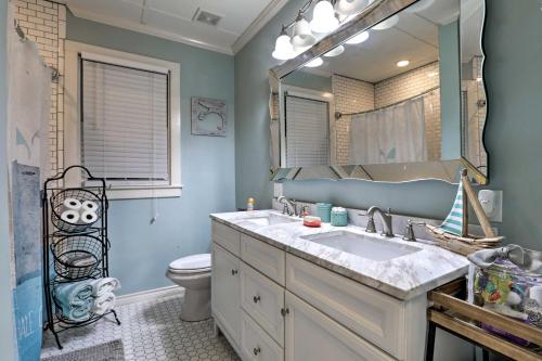 a bathroom with a sink and a toilet and a mirror at Historic Galveston Home Walkable Neighborhood! in Galveston