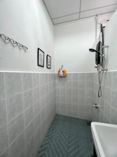 La salle de bains est pourvue d'une douche et d'un lavabo. dans l'établissement Hideaway ~ Best Memories start here!, à Mersing