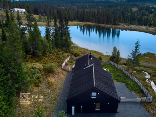 an overhead view of a black cabin next to a lake at Modern unique cabin fantastic location Skeikampen in Svingvoll