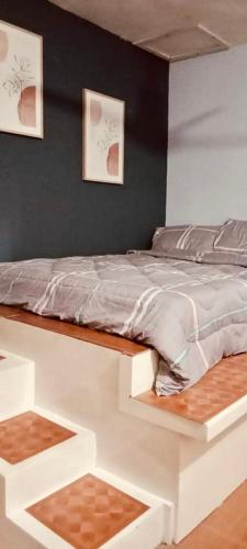 a white bed in a bedroom with two pictures on the wall at Affordable Staycation Home for 2-3 People! in Dauin